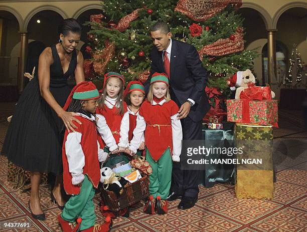 President Barack Obama and First Lady Michelle Obama pose with children dressed as elves as they arrive to attend the Christmas in Washington...