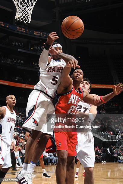 Bobby Simmons of the New Jersey Nets battles for a loose ball against Josh Smith of the Atlanta Hawks on December 13, 2009 at Philips Arena in...