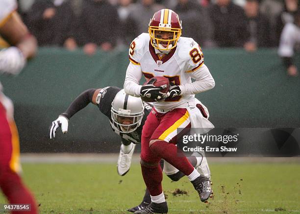 Santana Moss of the Washington Redskins runs with the ball during their game against the Oakland Raiders at Oakland-Alameda County Coliseum on...