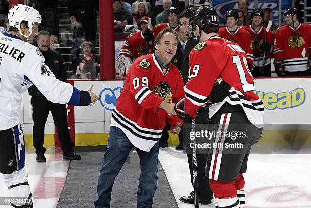 Actor Jim Belushi shakes hands with team captains Jonathan Toews of the Chicago Blackhawks and Vincent Lecavalier of the Tampa Bay Lightning on...