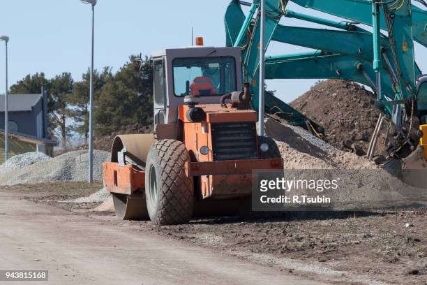 excavators and asphalt compactor truck - schrottpresse stock-fotos und bilder
