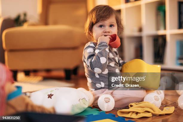 baby girl chewing and biting her toys - chewing stock pictures, royalty-free photos & images