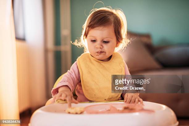 barn baby girl vill inte äta sin mat - baby eating bildbanksfoton och bilder