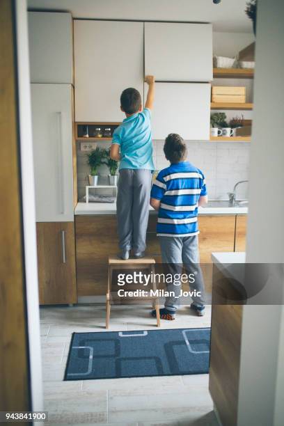 brothers stealing cookies in kitchen - child cookie jar stock pictures, royalty-free photos & images