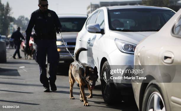Customs and Border Protection officer with canine inspects vehicles entering the United States at the San Ysidro port of entry on April 9, 2018 in...