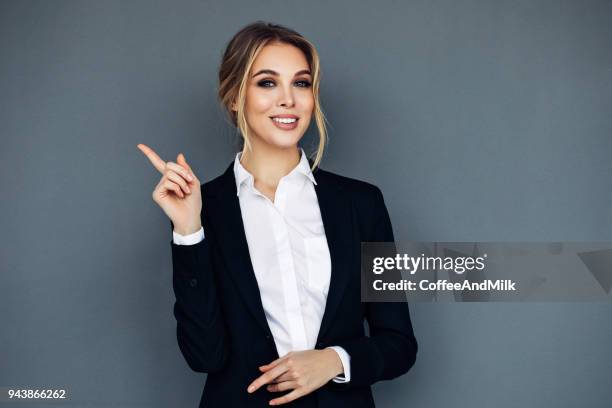 彼女の手に何かを示す笑顔ビジネス女性 - hand pointing ストックフォトと画像