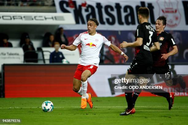 Leipzig's Danish forward Yussuf Poulsen vies with Leverkusen's Greek defender Panagiotis Retsos and Austrian midflielder Julian Baumgartlinger during...