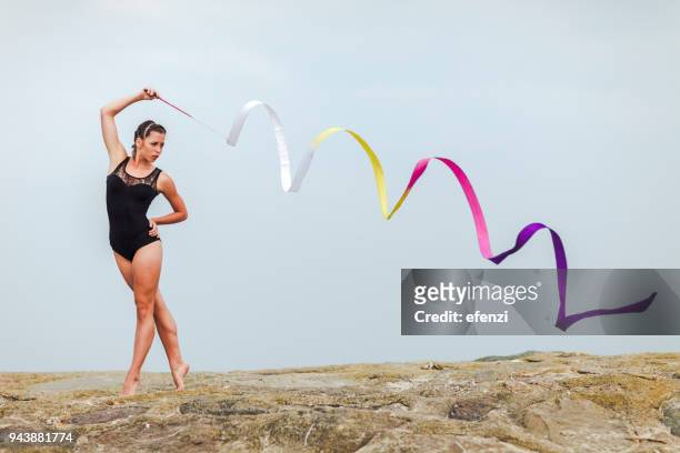 female gymnast training with ribbon outdoors at sea - artistic gymnastics stock pictures, royalty-free photos & images