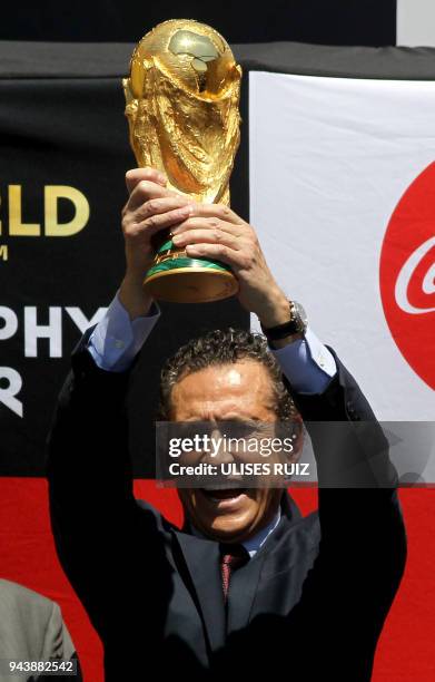 Argentina's former football player Jorge Valdano displays the FIFA World Cup trophy upon arrival at Miguel Hidalgo International Airport in...