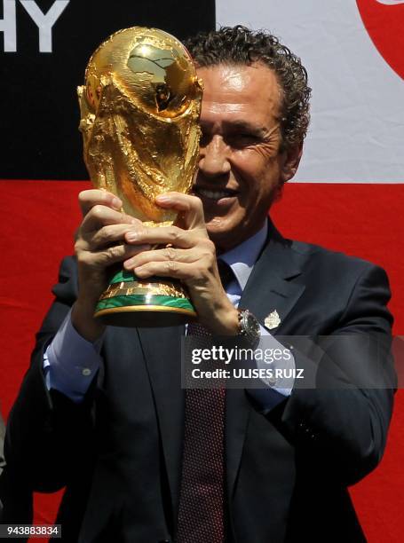 Argentina's former football player Jorge Valdano displays the FIFA World Cup trophy upon arrival at Miguel Hidalgo International Airport in...