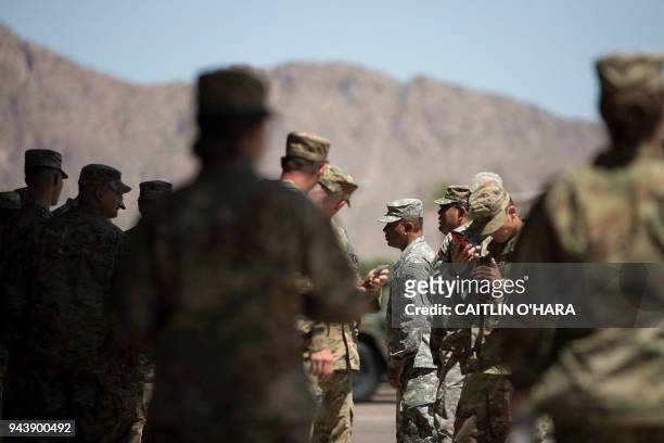 Members of the Arizona National Guard take a break on April 9, 2018 at the Papago Park Military Reservation in Phoenix. - Arizona deployed its first...