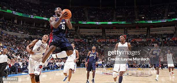 LeBron James of the Cleveland Cavaliers goes to the basket against Russell Westbrook and Kevin Durant of the Oklahoma City Thunder on December 13,...