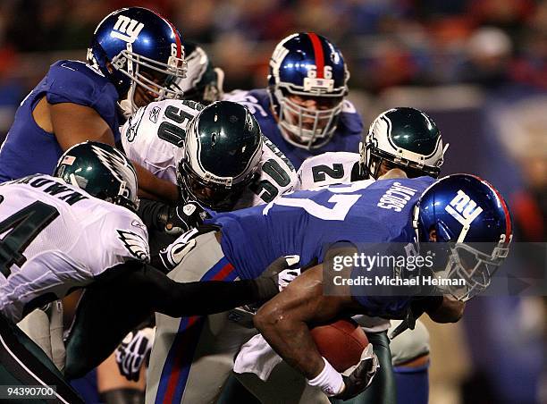 Brandon Jacobs of the New York Giants runs the ball against Sheldon Brown and Will Witherspoon of the Philadelphia Eagles at Giants Stadium on...