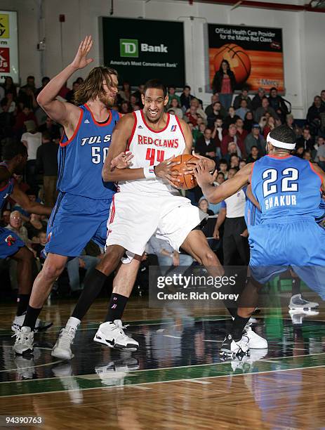 Steven Hill and Mustafa Shakur of the Tulsa 66ers swarm Alexis Ajinca of the Maine Red Claws during the game on December 13, 2009 at the Portland...