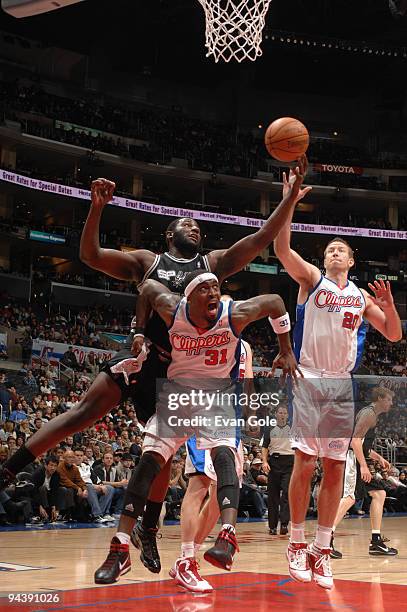 DeJuan Blair of the San Antonio Spurs battles for a loose ball against Ricky Davis and Steve Novak of the Los Angeles Clippers at Staples Center on...