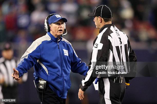 Head coach Tom Coughlin of the New York Giants talks with field judge Scott Edwards about a play against the Philadelphia Eagles at Giants Stadium on...