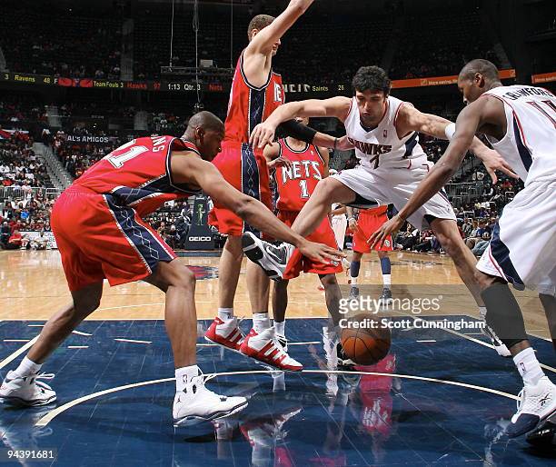Bobby Simmons of the New Jersey Nets battles for a loose ball against Zaza Pachulia and Jamal Crawford of the Atlanta Hawks on December 13, 2009 at...