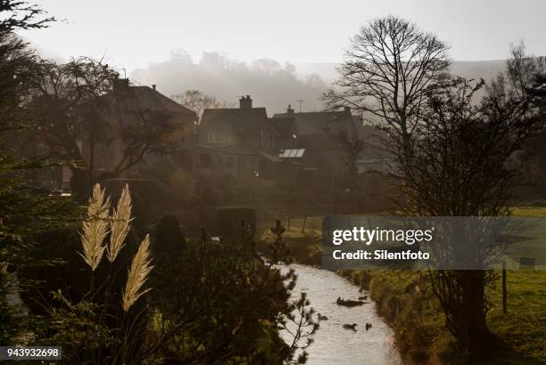 a small brook runs behind houses beneath ruins of peveril castle, castleton - silentfoto sheffield 個照片及圖片檔