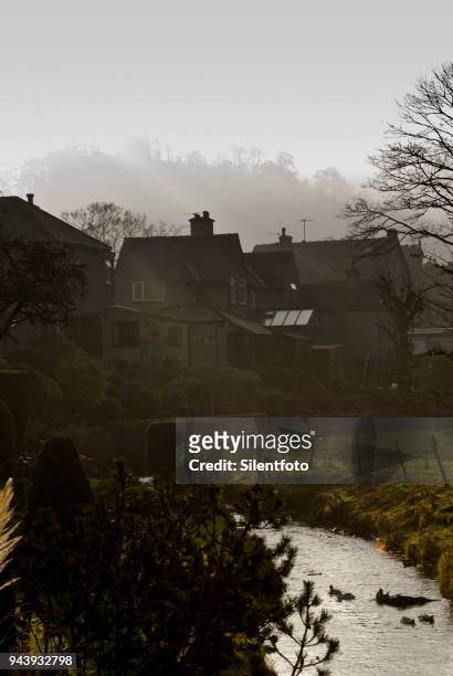 a small brook runs behind houses beneath ruins of peveril castle, castleton - silentfoto sheffield stock-fotos und bilder