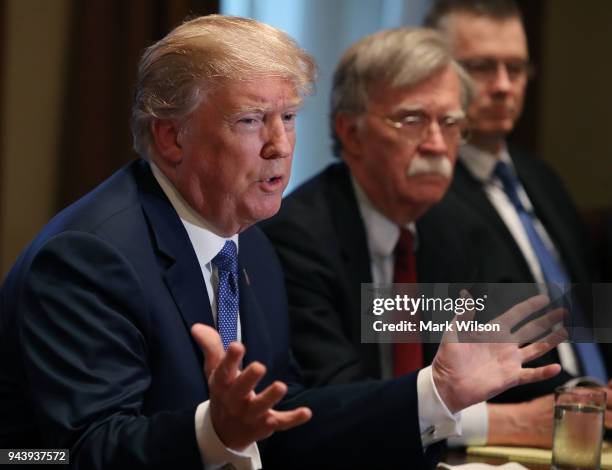 President Donald Trump is flanked by National Security Advisor John Bolton as he speaks about the FBI raid at his lawyer Michael Cohen's office,...