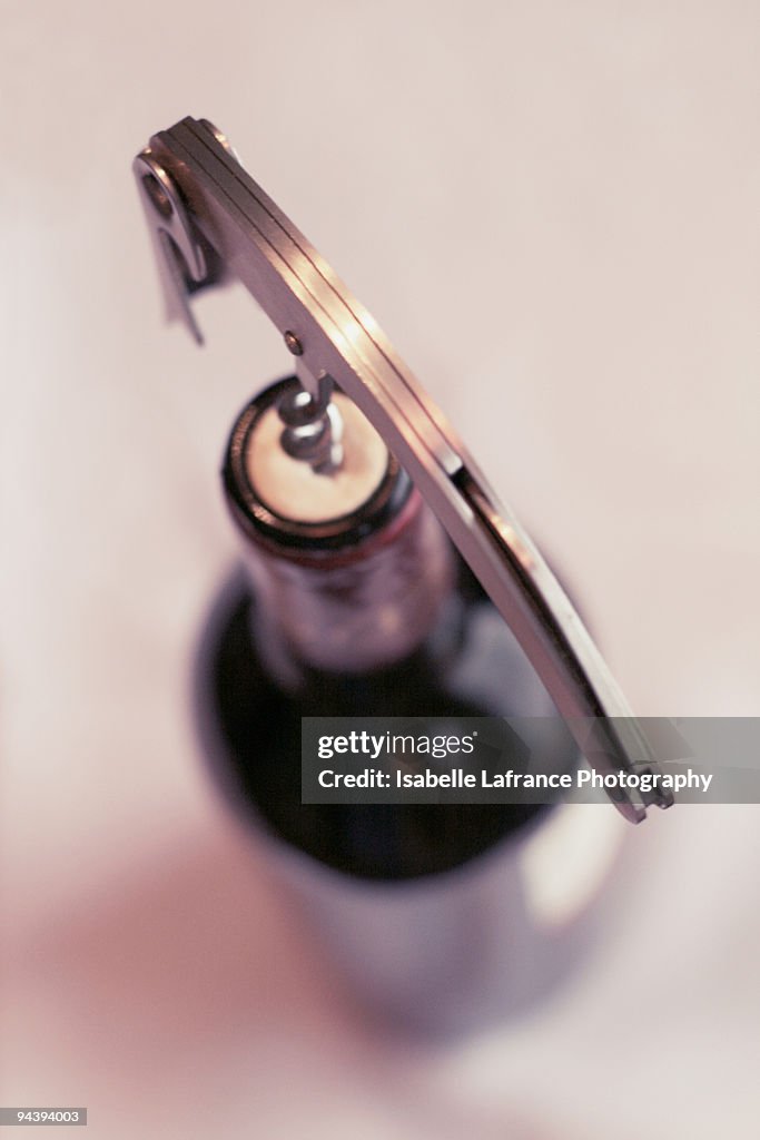 Corkscrew on top of a bottle of red wine