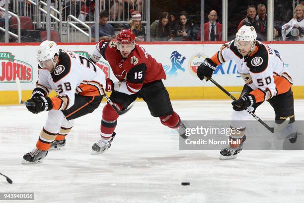 Brad Richardson of the Arizona Coyotes skates after a loose puck between Antoine Vermette and Derek Grant of the Anaheim Ducks at Gila River Arena on...