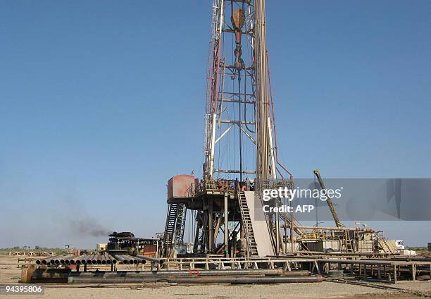 Iraqi labourers work at the Halfaya oil field near the southern city of Amara in Iraq's southern Maysan province on December 12, 2009. Asian firms...