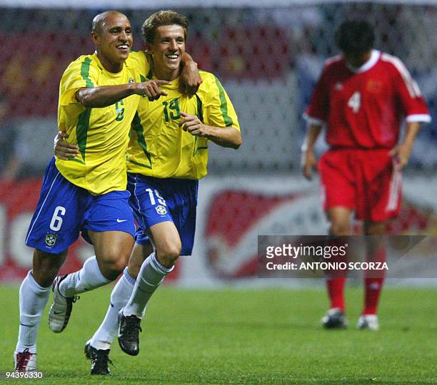 Brazil's Roberto Carlos runs with Juninho Paulista after scoring off a 14th minute free-kick as China's Wu Chengying looks down, 08 June 2002 at the...