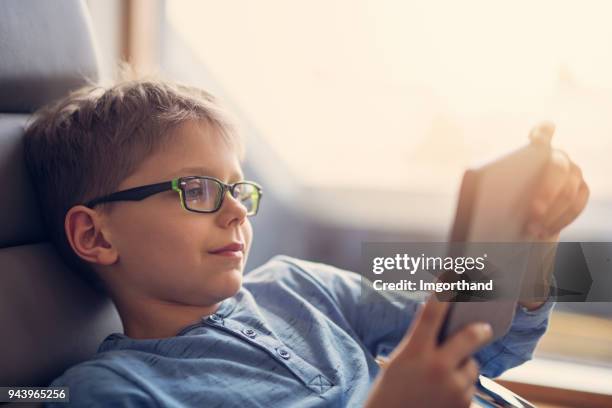 little boy reading an ebook - science and technology ebook stock pictures, royalty-free photos & images