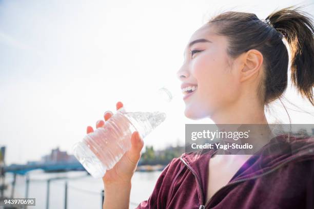 young woman drinking water - running refreshment stock pictures, royalty-free photos & images