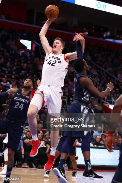 Jakob Poeltl of the Toronto Raptors drives to the basket past Reggie Jackson of the Detroit Pistons during the second half at Little Caesars Arena on...