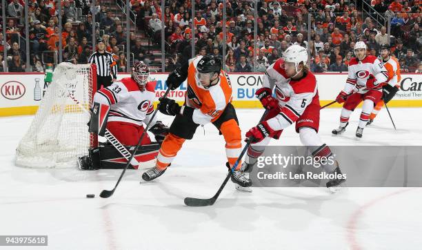 Michael Raffl of the Philadelphia Flyers skates the puck on a scoring opportunity against Noah Hanifin and Scott Darling of the Carolina Hurricanes...