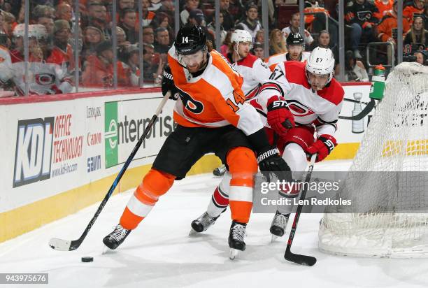 Sean Couturier of the Philadelphia Flyers skates the puck behind the net against Trevor van Riemsdyk of the Carolina Hurricanes on April 5, 2018 at...