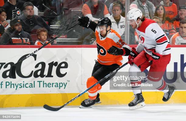 Michael Raffl of the Philadelphia Flyers battles along the boards against Noah Hanifin of the Carolina Hurricanes on April 5, 2018 at the Wells Fargo...