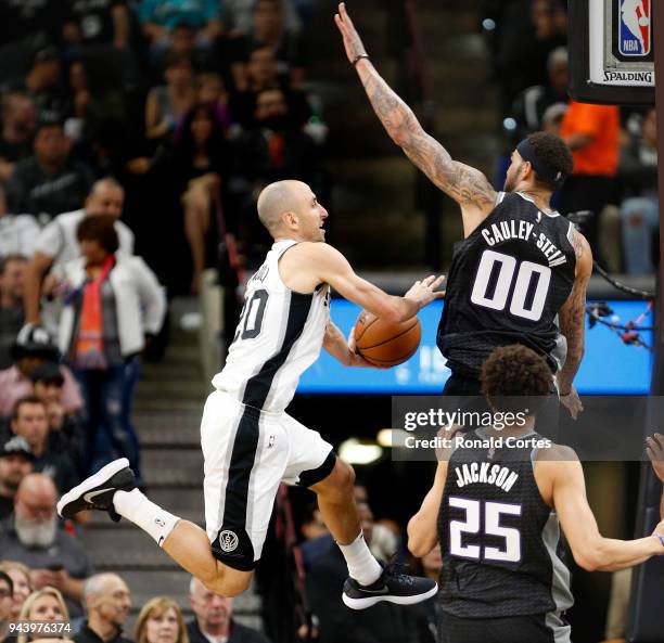 Manu Ginobili of the San Antonio Spurs passes off against Willie Cauley-Stein of the Sacramento Kings at AT&T Center on April 9 , 2018 in San...