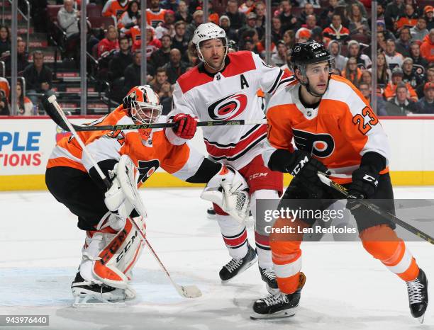 Brandon Manning and Brian Elliott of the Philadelphia Flyers battle in the crease against Justin Williams of the Carolina Hurricanes on April 5, 2018...