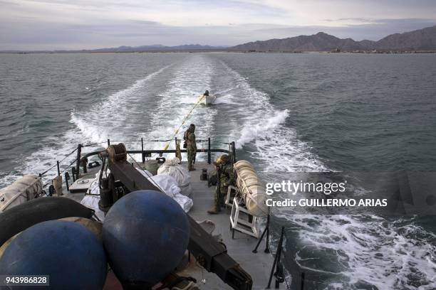 Navy officers stand guard on the M/V Farley Mowat as it navigates near San Felipe, in the Gulf of California, Baja California state, northwestern...