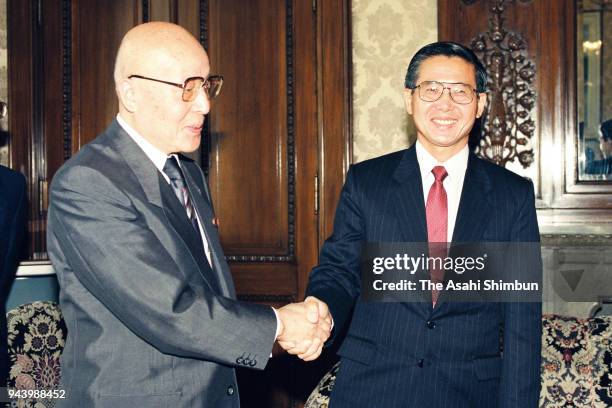 Peruvian incoming president Alberto Fujimori and Lower House speaker Yoshio Sakurauchi shake hands prior to their meeting at the Diet building on...