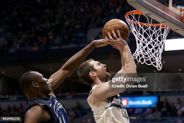 Tyler Zeller of the Milwaukee Bucks attempts a shot while being guarded by Bismack Biyombo of the Orlando Magic in the second quarter at the Bradley...