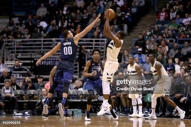 Khris Middleton of the Milwaukee Bucks attempts a shot while being guarded by Aaron Gordon of the Orlando Magic in the third quarter at the Bradley...