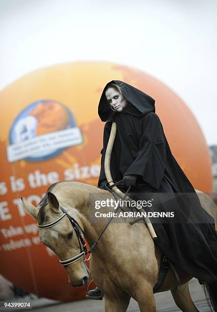 Woman dressed as "Death", of the Four Horsemen of the Apocalypse, during a Greenpeace demonstration in Parliament Square in Copenhagen on December...