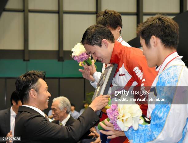 Yasuhiro Koseki receives the trophy by Kosuke Kitajima on the podium at the medal ceremony for the Men's 200m Breaststroke on day five of the Japan...