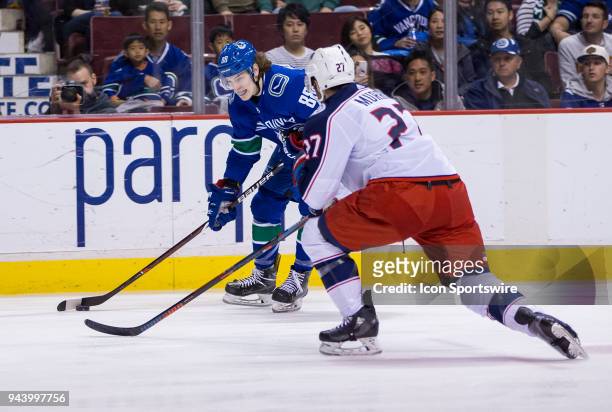 Vancouver Canucks Center Adam Gaudette handles the puck behind Columbus Blue Jackets Defenceman Ryan Murray during the third period in a NHL hockey...