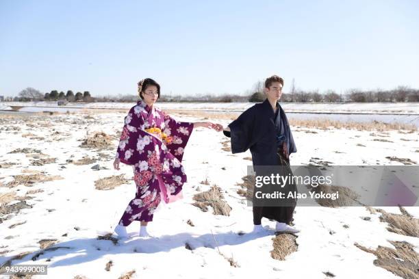 i took a young man and a girl in a kimono and was walking along the snowy riverbed - kimono winter stock pictures, royalty-free photos & images
