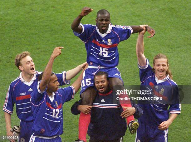 French defender Lilian Thuram , who scored the two goals for his team, is carried on the shoulders of goalkeeper Bernard Lama as they celebrate with...