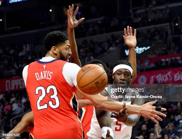 Montrezl Harrell of the Los Angeles Clippers passes underneath the basket against Anthony Davis of the New Orleans Pelicans in the first half of the...