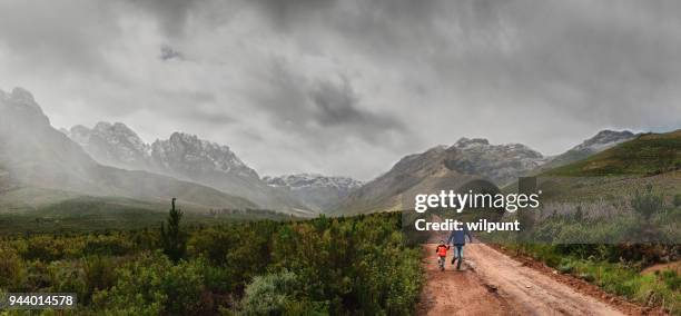 vader en zoon uitgevoerd samen tussen en met sneeuw bedekte bergen - stellenbosch stockfoto's en -beelden