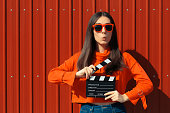 Beautiful Woman with Cinema Clapper on Red Background