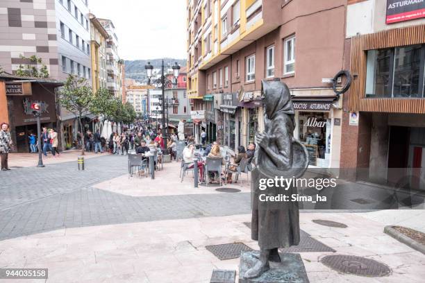 people relaxing on gascona street - the gastronomic heart of oviedo, spain. la gitana (gypsy woman) monument in front. - oviedo stock pictures, royalty-free photos & images