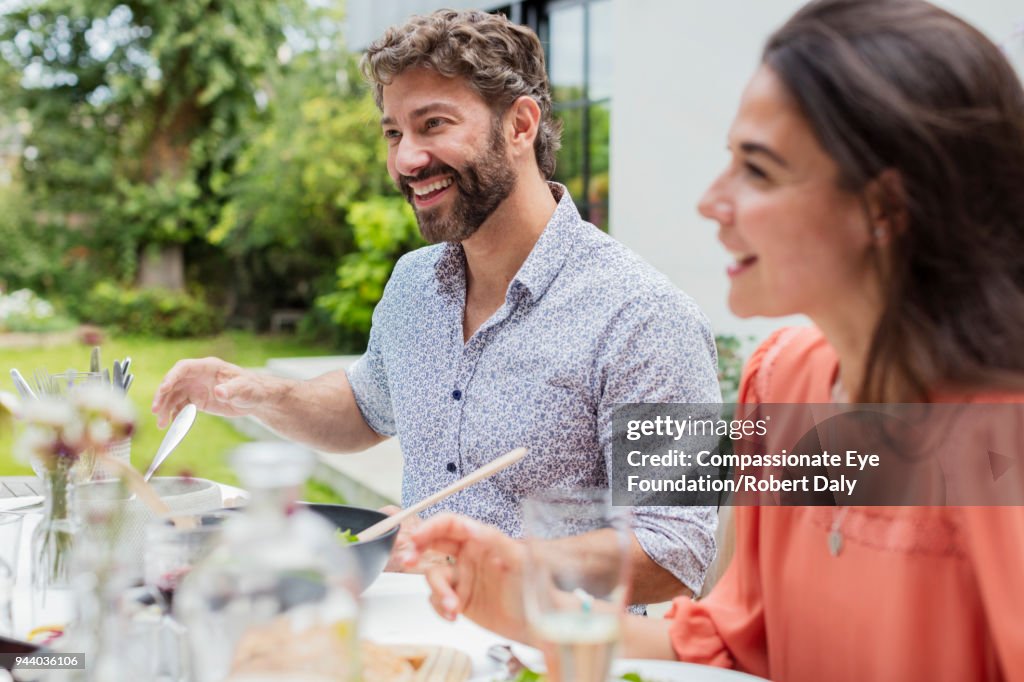 Smiling couple having lunch on garden patio